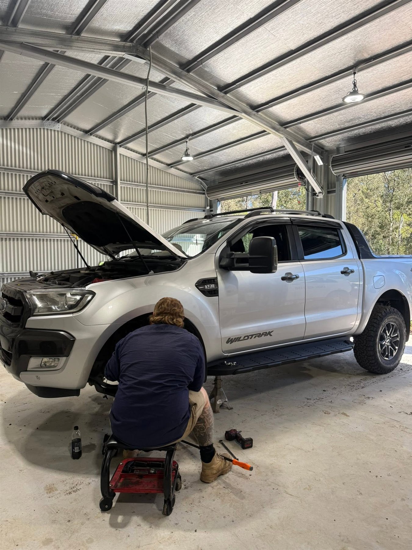 Mechanic working on a vehicle inside the Amped Up Automotive workshop in Woodhill